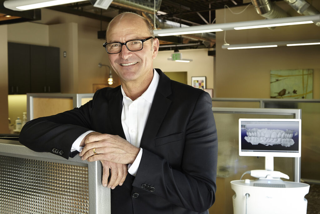 World-renowned dental surgeon smiling and posing in his modern dental office.