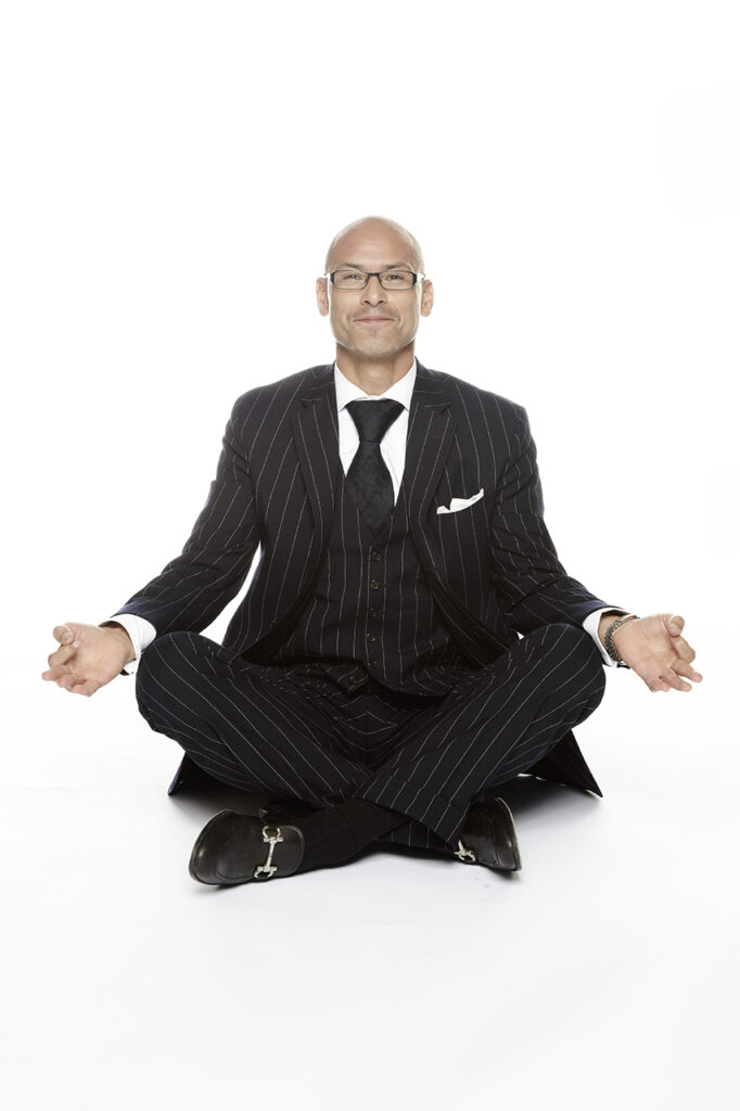 Attorney at GMH Law sitting in a meditative pose, wearing a pinstripe suit, captured by Visionary Headshots.